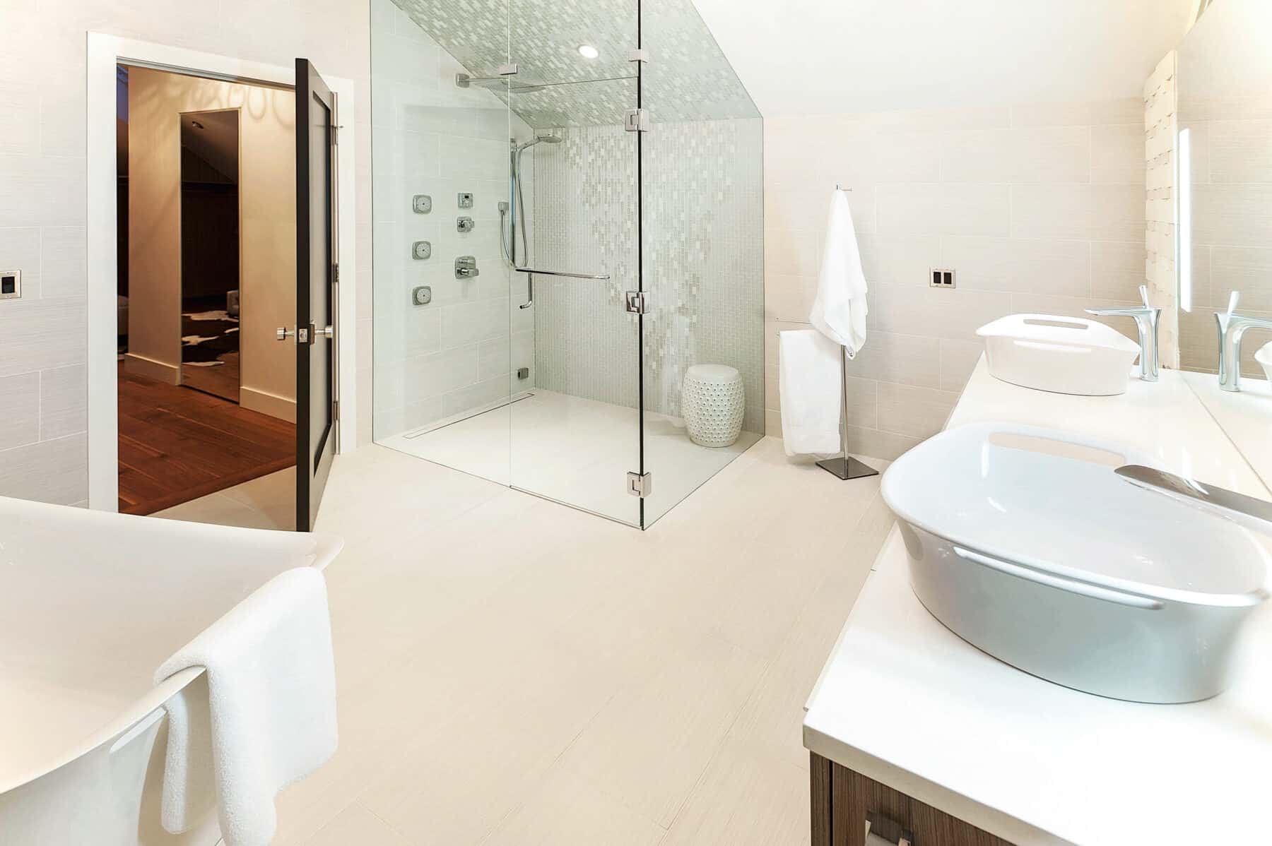 White on White Master Bathroom with Glass Shower Walls in Aspen, Colorado Custom Home. Luxury Home Building Interiors