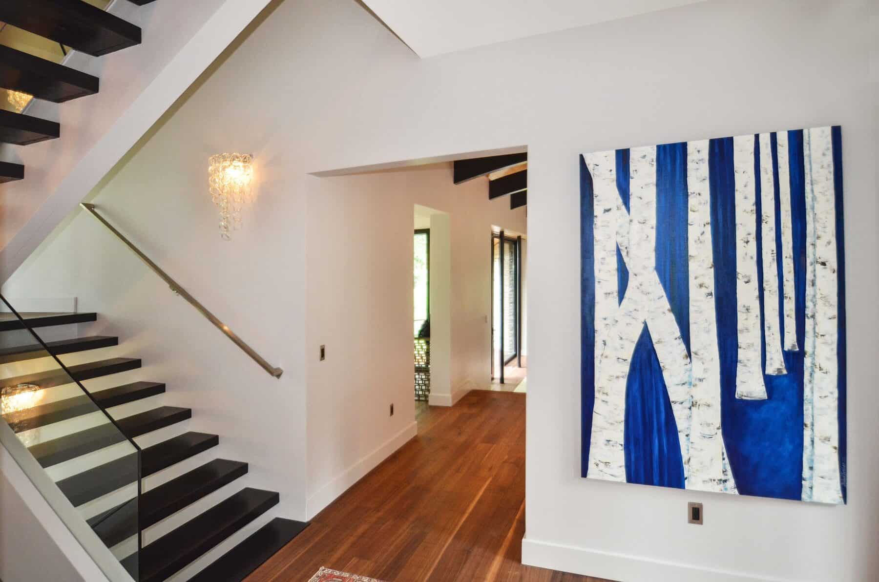 Black Floating Stair case and Blue and White Aspen Tree Painting by Michael Kessler in Aspen, Colorado Custom Home. Luxury Home Building Interiorsrado Custom Home. Luxury Home Building Interiors