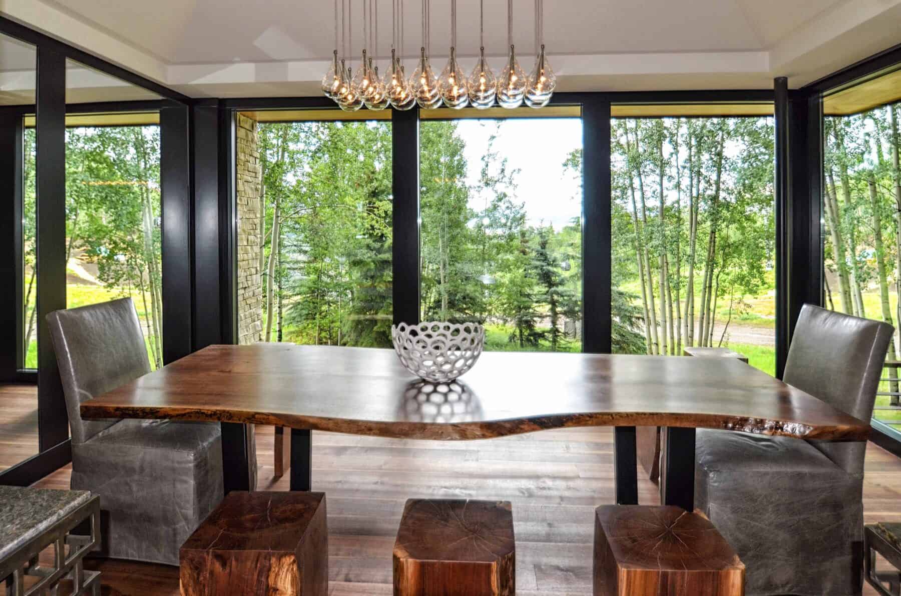 A Beautiful Modern Dining Room with Surrounding Black Windows in Aspen, Colorado Custom Home. Luxury Home Building Interiors