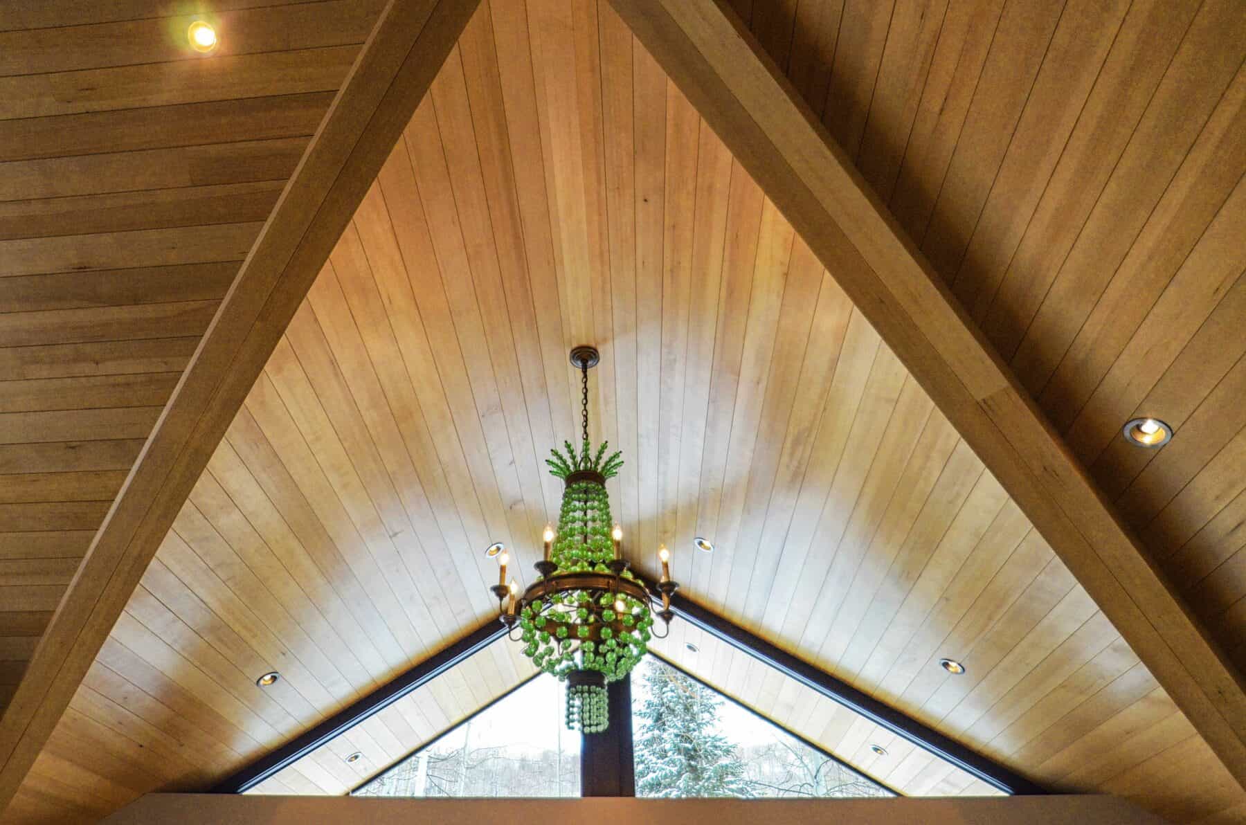 Wood Ceiling with Matching Beams Accentuated by Green Glass Chandelierin Aspen, Colorado Custom Home. Luxury Home Building Interiors
