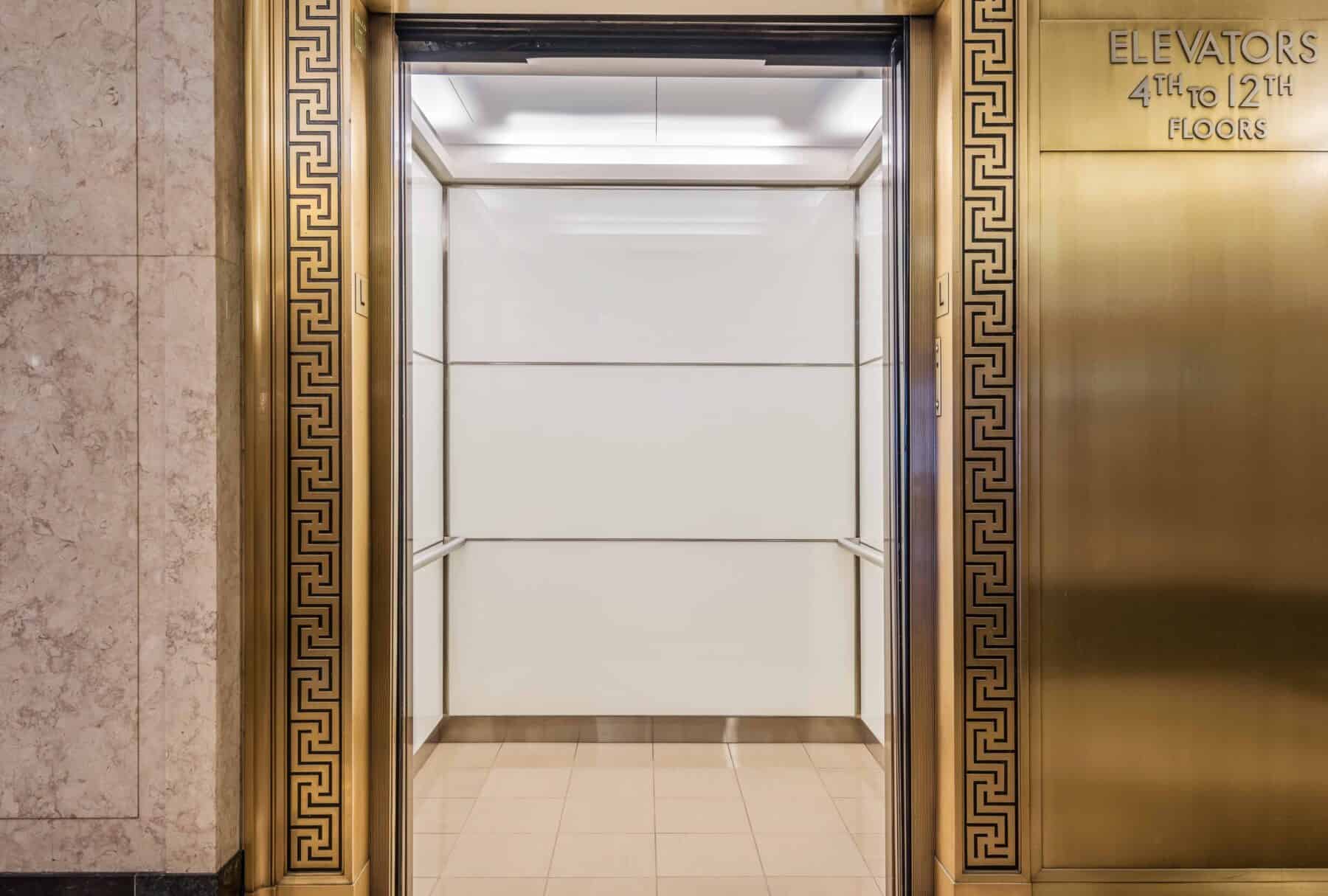 Custom Elevator Interior with Back Painted Glass Wall Panels and LED Ceiling Lights for Burnham Center Remodel by Commercial Builder & General Contractor Structural Enterprises