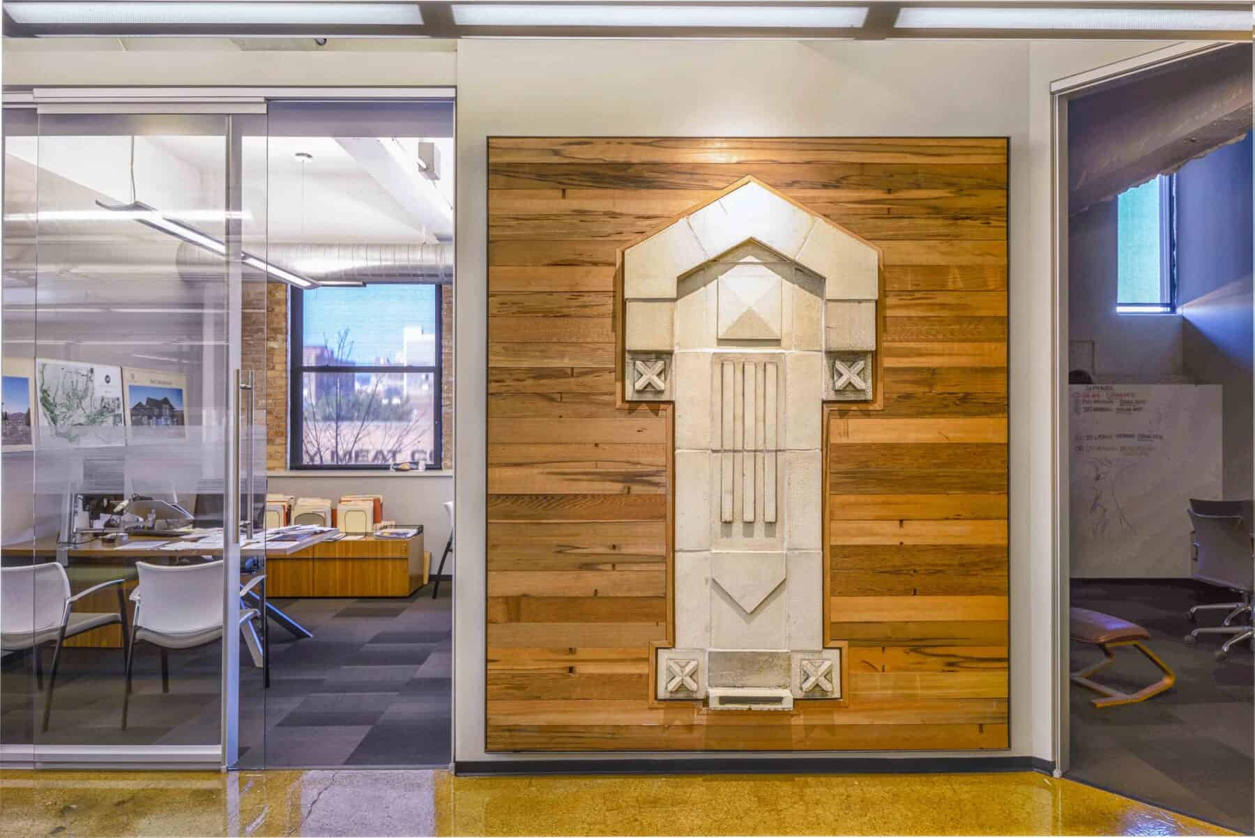 Office Remodel with a Featured Wall of Original Reclaimed Wood and Stone Artifact found in the Building by Commercial Builder & General Contractor Structural Enterprises