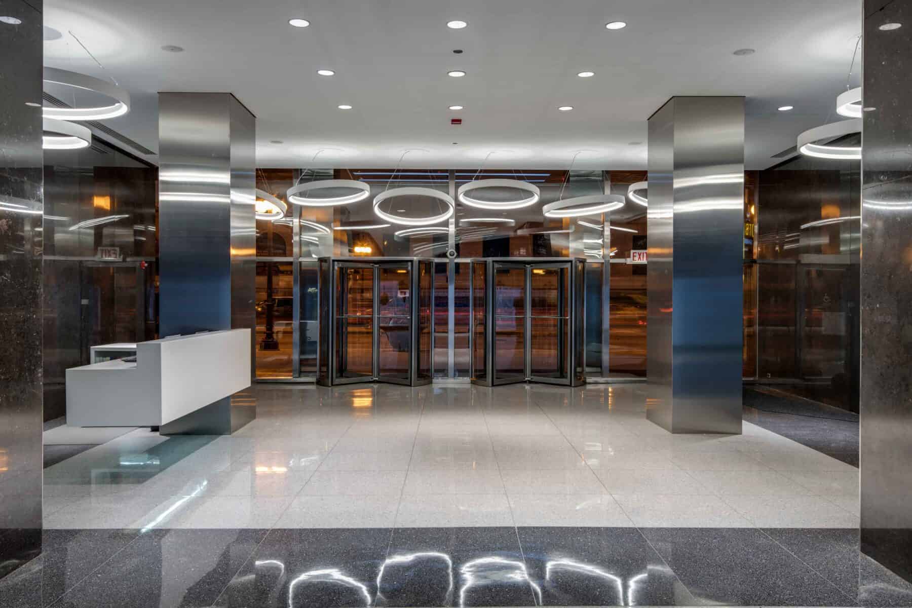 Modern Lobby Remodel with Circular Lights and Floating Reception Desk by Commercial Builder & General Contractor Structural Enterprises