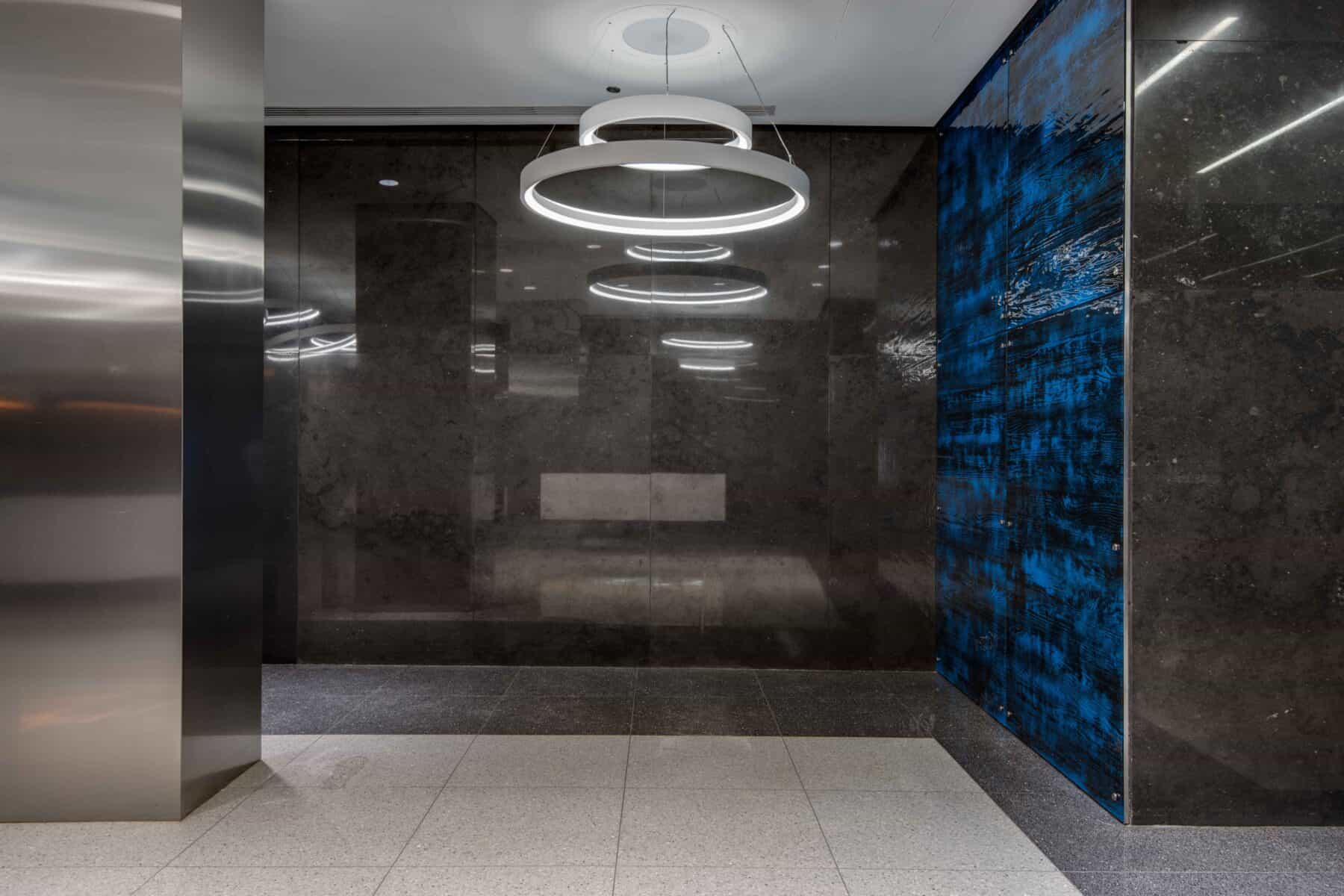 Modern Lobby Remodel with Custom Circular lights and Glass Wall Panels by Commercial Builder & General Contractor Structural Enterprises