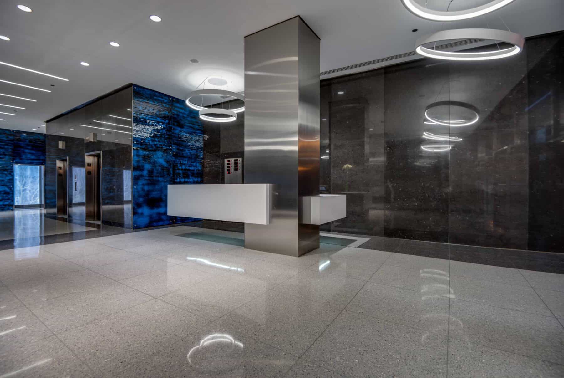 Michigan Avenue Lobby Remodel with Glass Wall Panels, Floating Reception Desk and Suspended LED Lights by Commercial Builder & General Contractor Structural Enterprises