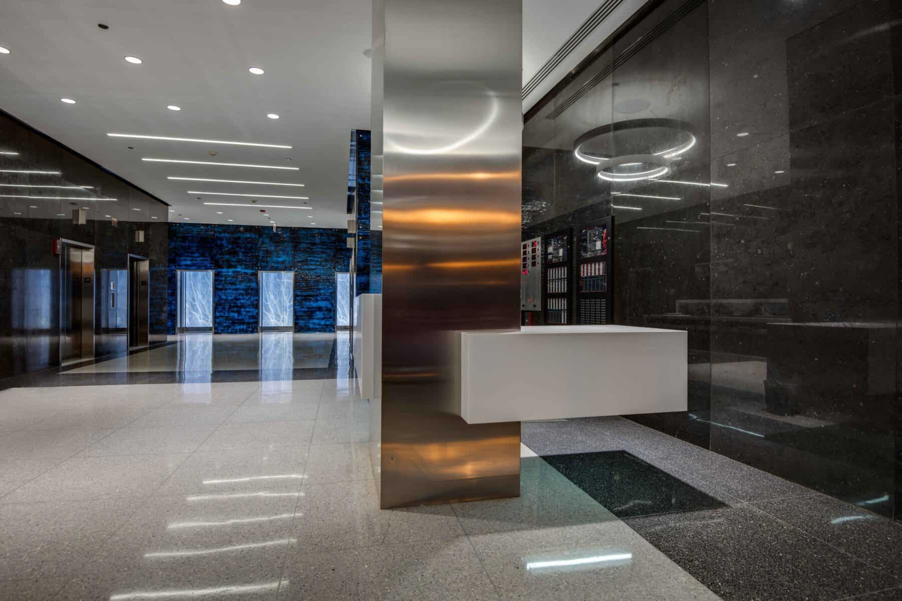 Modern Michigan Avenue Lobby Remodel with Custom Glass Wall Panels and White Floating Reception Desk at by Commercial Builder & General Contractor Structural Enterprises