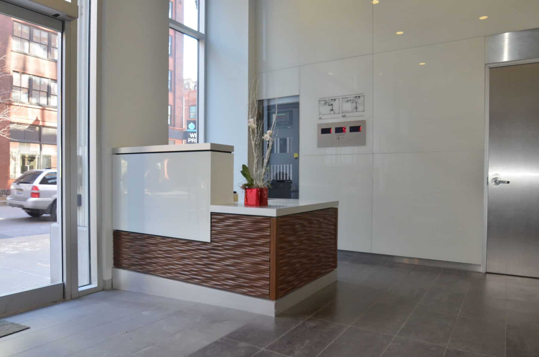 Custom Reception Desk and Glass Wall Panels for Randolph Street Lobby remodel by Commercial Builder & General Contractor Structural Enterprises