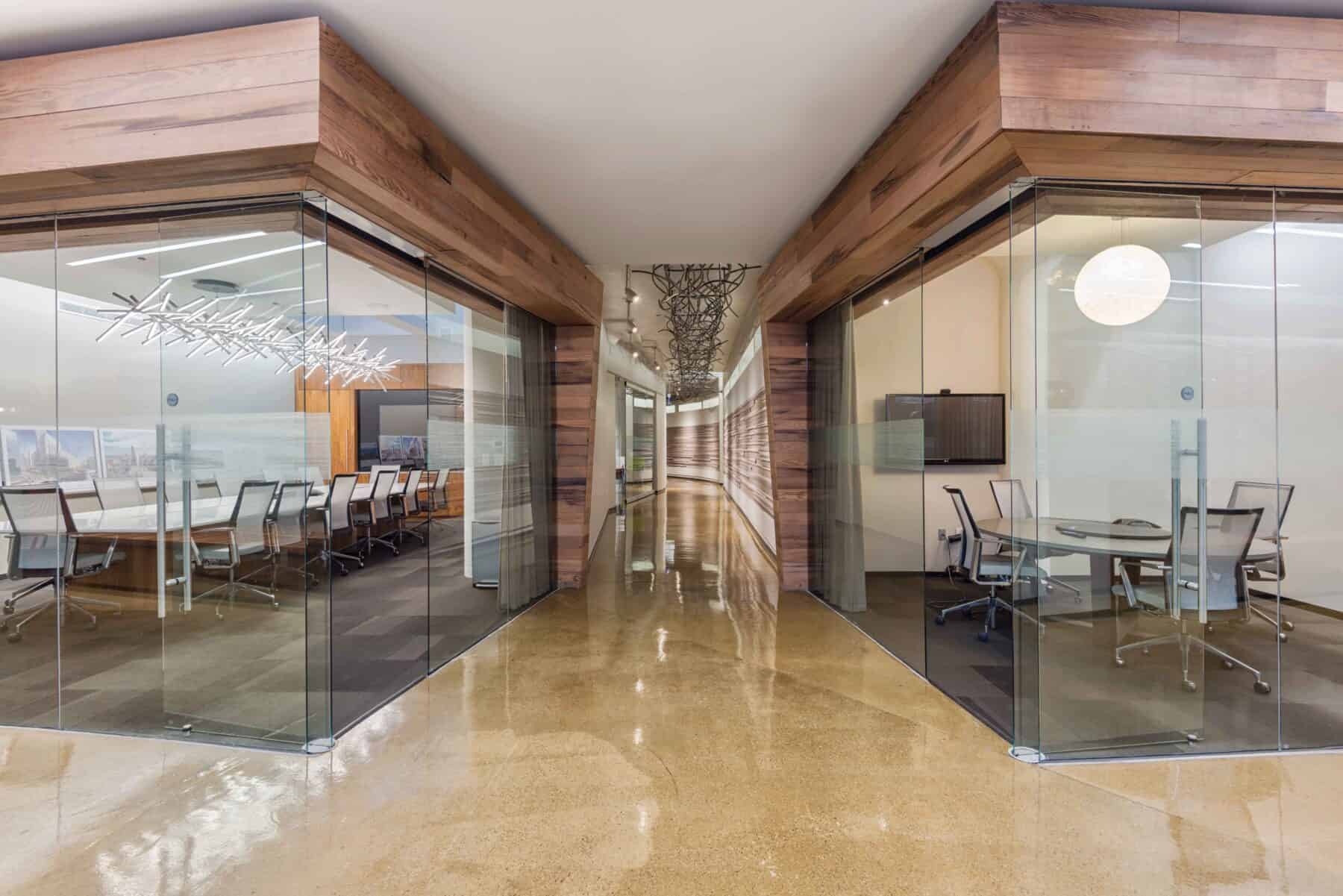 Spectacular Office Remodel with Floor to Ceiling Glass Wall and Doors with Custom Wood Work and Metal Art by Commercial Builder & General Contractor Structural Enterprises