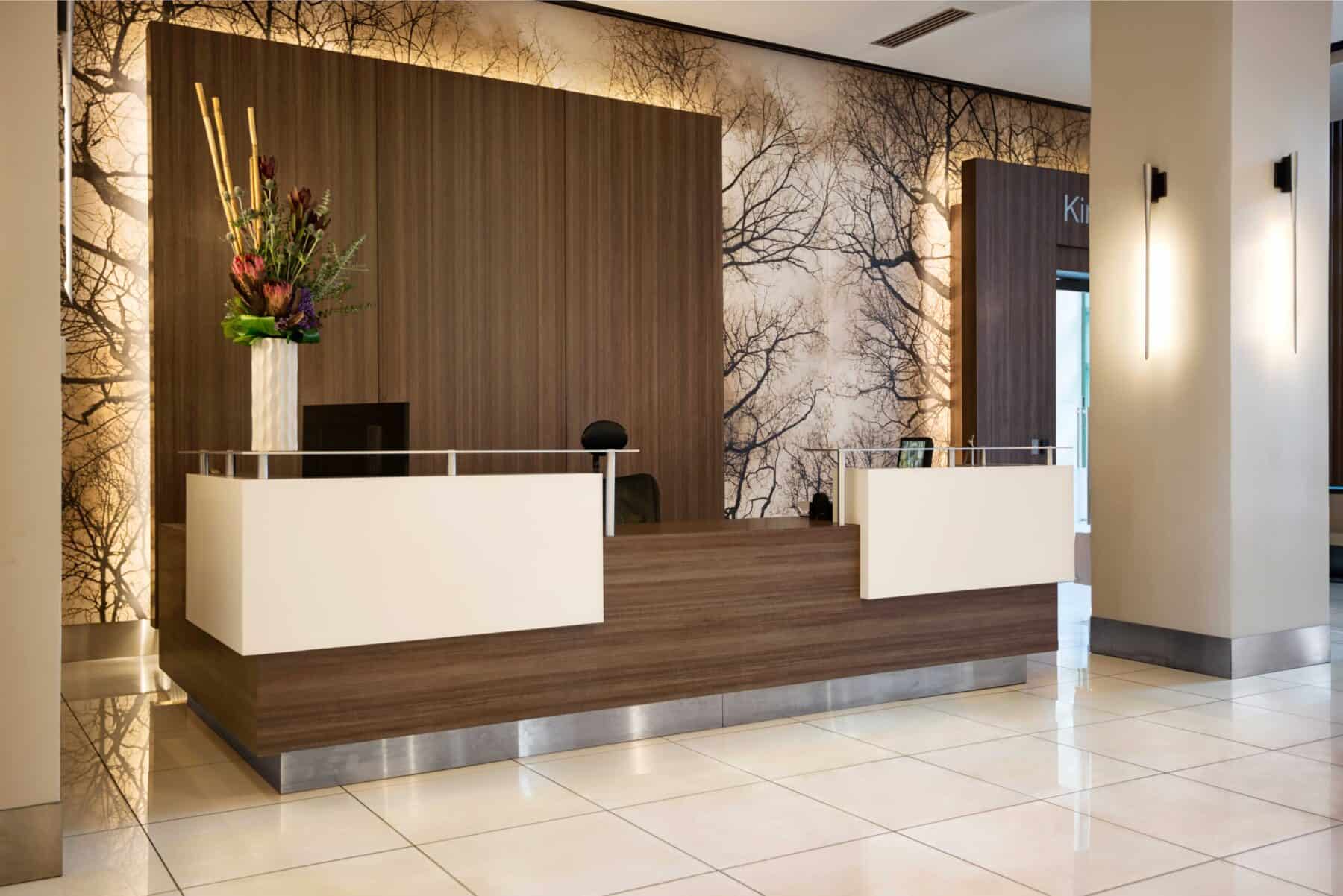 Modern Reception Desk White Hard Surface Material and Metal Details by Commercial Builder & General Contractor Structural Enterprises