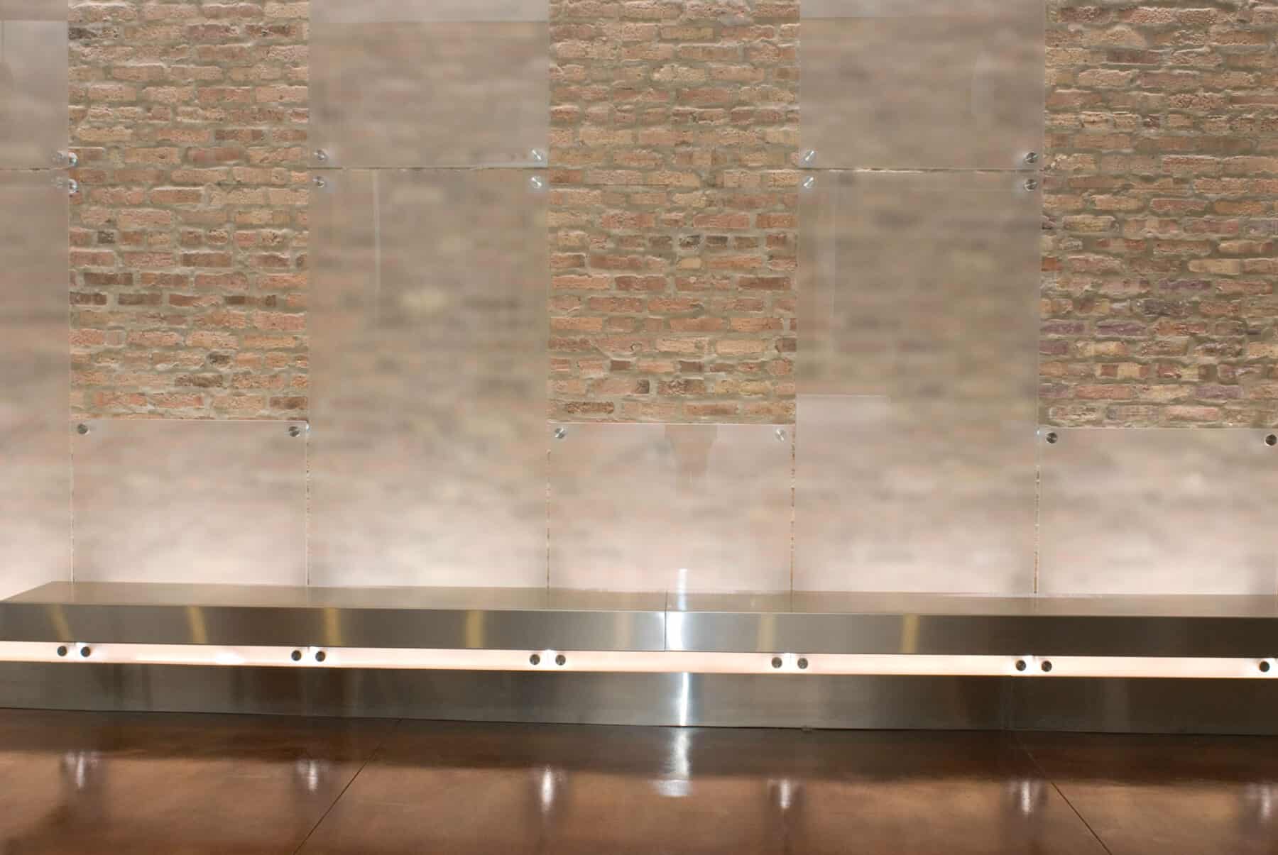 Custom Etched Glass Wall Panels with Metal Floating Bench on Brick Wall for West Jackson Lobby Remodel by Commercial Builder & General Contractor Structural Enterprises